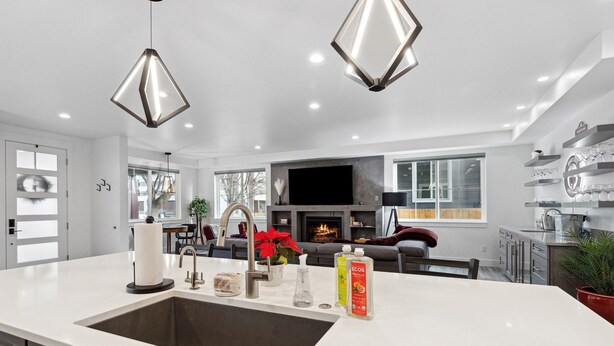 A modern kitchen with a large island, built-in appliances, and a fireplace.