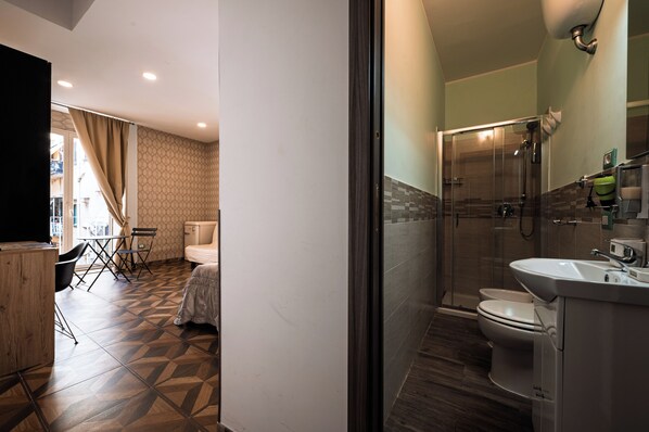 Un baño moderno con cabina de ducha de vidrio, inodoro y lavamanos.
