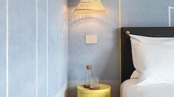 Una camera da letto ordinata con un letto, comodini e lampade a sospensione.