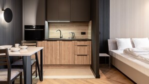 Une cuisine de taille réduite, dotée de meubles de rangement en bois, d’une cuisinière encastrée et d’un évier.