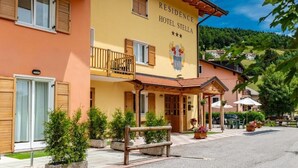 A hotel named "Residence Hotel Stella" with a balcony, outdoor seating, and a view of the surrounding area. - RESIDENCE STELLA (Folgaria)