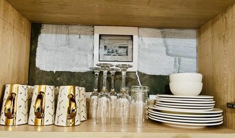A wooden cabinet with glassware and plates.