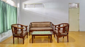 A room with a sofa, two armchairs, and a small table. There are windows with blinds and a door. - SPOT ON 93717 Nayus Homestay Syariah 4 (Yogyakarta)