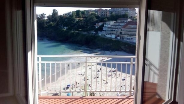 A balcony with a view of a beach and buildings. - Apartment 3 Bedrooms with WiFi and Sea views (Portonovo)