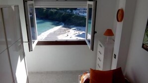 A bedroom with a window view of a beach and ocean. - Apartment 3 Bedrooms with WiFi and Sea views (Portonovo)