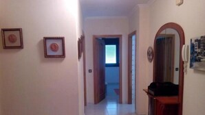 A hallway with framed pictures on the walls, a wooden cabinet, and a mirror. - Apartment 3 Bedrooms with WiFi and Sea views (Portonovo)