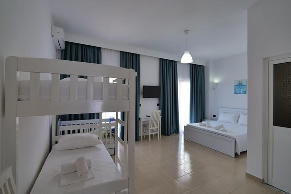 A hotel room with a bunk bed, a single bed, a desk with a chair, and a TV. - El Mare Hotel (Sarandë)