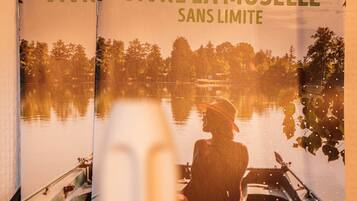 Eine Broschüre mit dem Titel "15 Experiences pour vivre la moselle sans limite", die einen friedlichen See und eine Bootsfahrt zeigt.