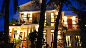 A multi-story building with balconies, large windows, and a stone facade. - Villa Ferrer (Mahatao)