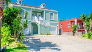 A two-story house with a front porch and a garage. - Casa Caracol - Pool - Walk to the Beach, WiFi (South Padre Island)