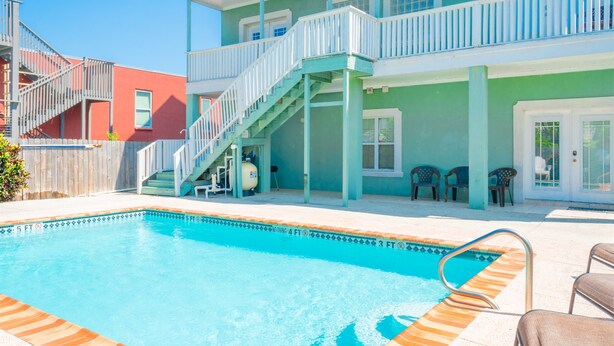 A two-story building with a pool area, including a staircase and outdoor seating. - Casa Caracol - Pool - Walk to the Beach, WiFi (South Padre Island)