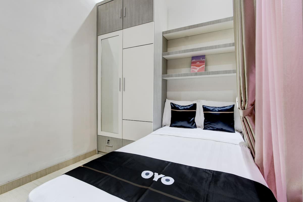 A bedroom with a bed, a wardrobe, and a shelf unit.