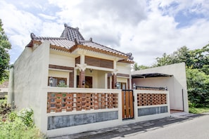 A two-story house with a tiled roof, a balcony, and a gated entrance. - Capital O 93718 Homestay 3 Bidadari (Moyudan)