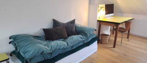 Una habitación estilo loft con una cama, un escritorio y una computadora.