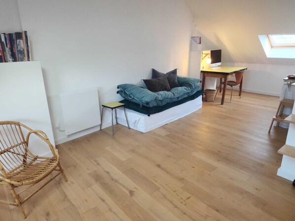 A loft-style room with a bed, a desk, a chair, and a skylight. - Fisherman's cottage / historic center (fecamp)