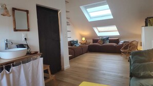 A loft-style living space with a skylight, a built-in sink, a sofa, and a chair. - Fisherman's cottage / historic center (fecamp)