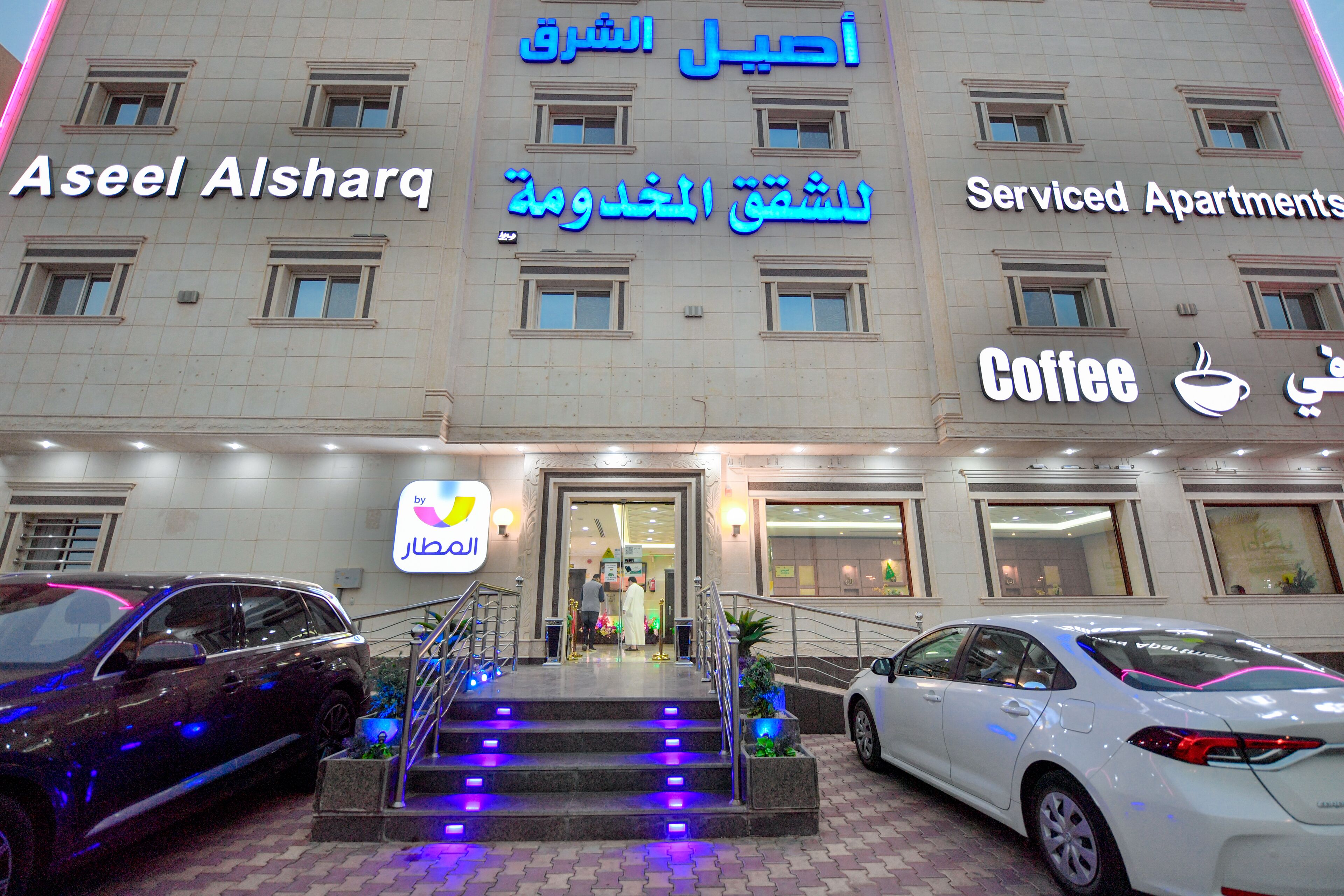 Ein Gebäude mit Schildern für "Aseel Alsharq" und "Serviced Apartments".