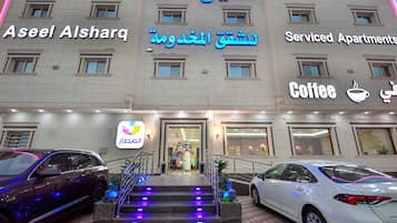 Un immeuble portant une enseigne indiquant « Aseel Alsharq » et « Appartements avec services ».