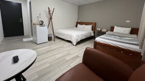 Een hotelkamer met een bed, een bureau, een stoel en een klein tafeltje.
