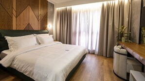 Ein modernes Hotelzimmer mit einem großen Bett, einer Wand aus Holzpaneelen und Blick ins Freie durch Vorhänge.
