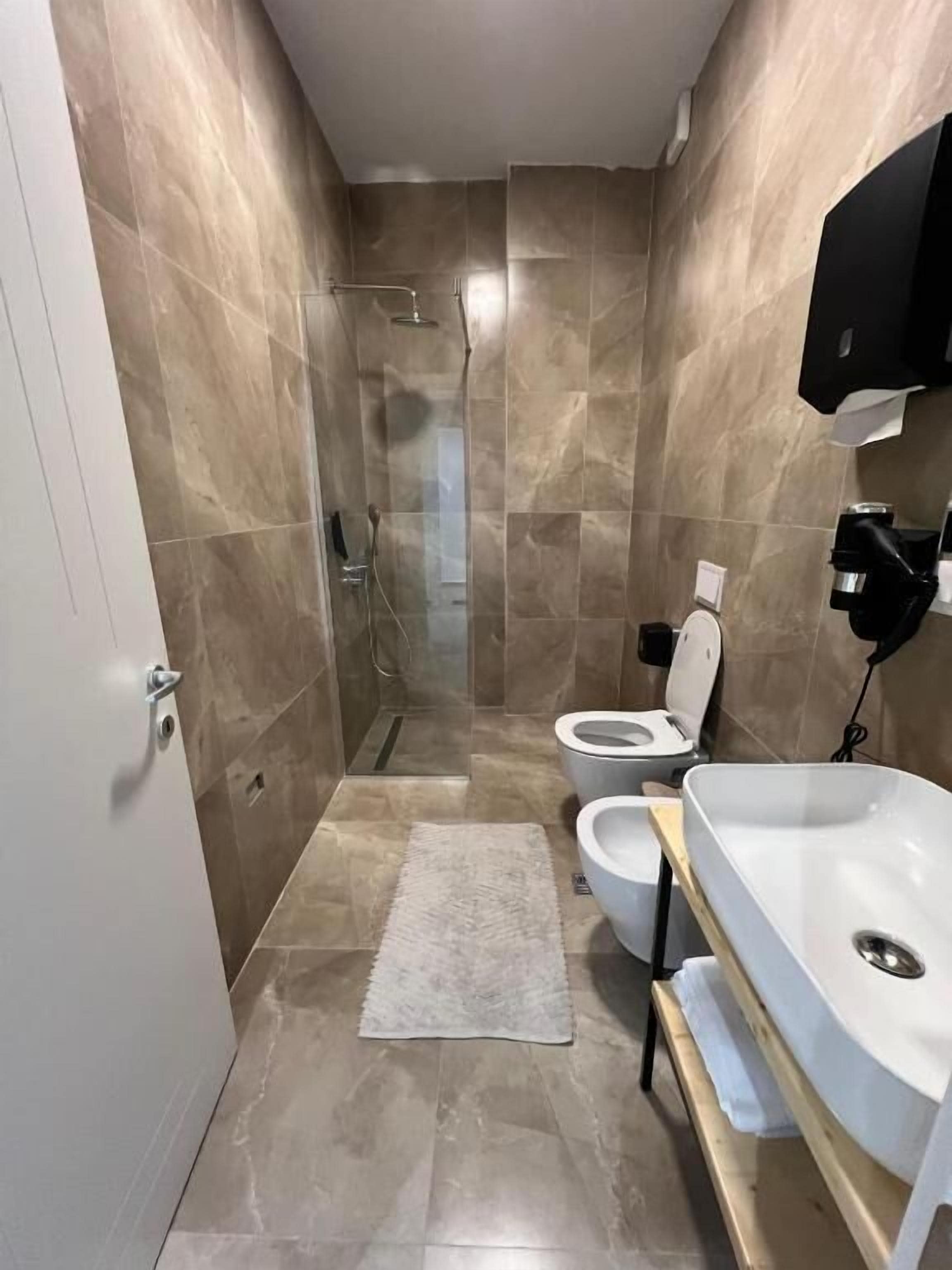 Un baño con ducha, inodoro y lavabo.