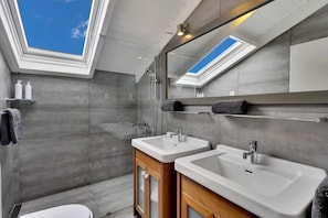 A modern bathroom with skylights, two sinks, and a large mirror. - Belmar Oceanfront Apartments 12 located directly on the sea with diving facilities (Kralendijk)
