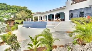 A modern house with a pool, outdoor seating, and lush landscaping. - Villa Heros Sabadeco (Kralendijk)