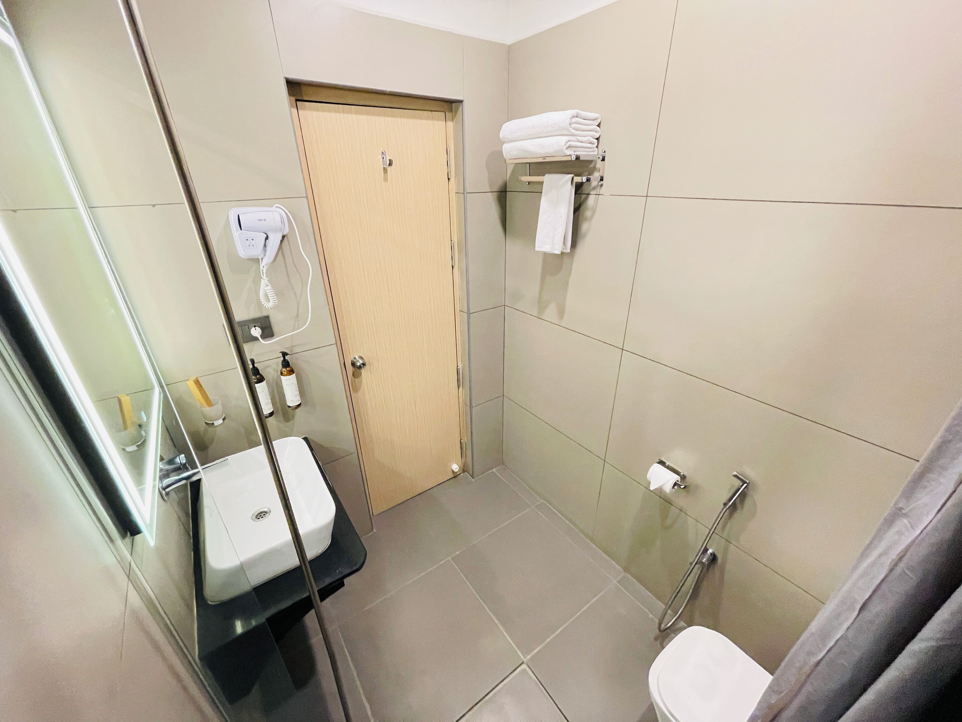 A bathroom with a toilet, a sink, a shower, and a towel rack.