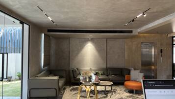 A modern interior with a sofa, coffee table, and a glass partition.