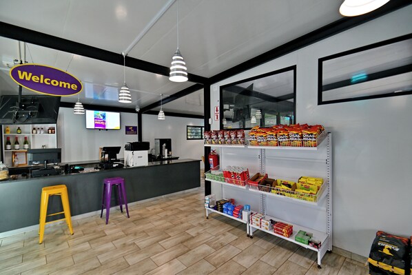 Un interno pulito e moderno con una reception, un bar e scaffali pieni di snack.