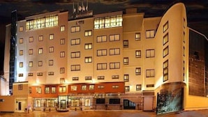 A multi-story hotel with a central entrance, large windows, and a sign indicating it is a hotel. - Ambassadeurs Oran (Oran)