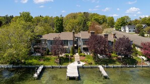 A residential building with a dock and a clear water body in front.