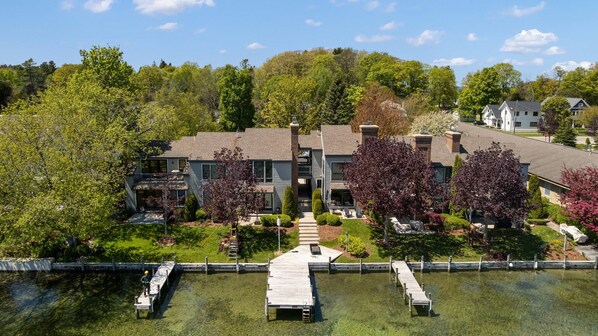 A residential building with a dock and a clear water body in front.