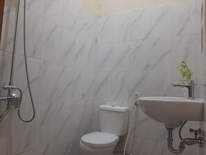 A bathroom with a toilet, a sink, and a shower. - Capital O 93719 Homestay Omah Bidadari (Prambanan)