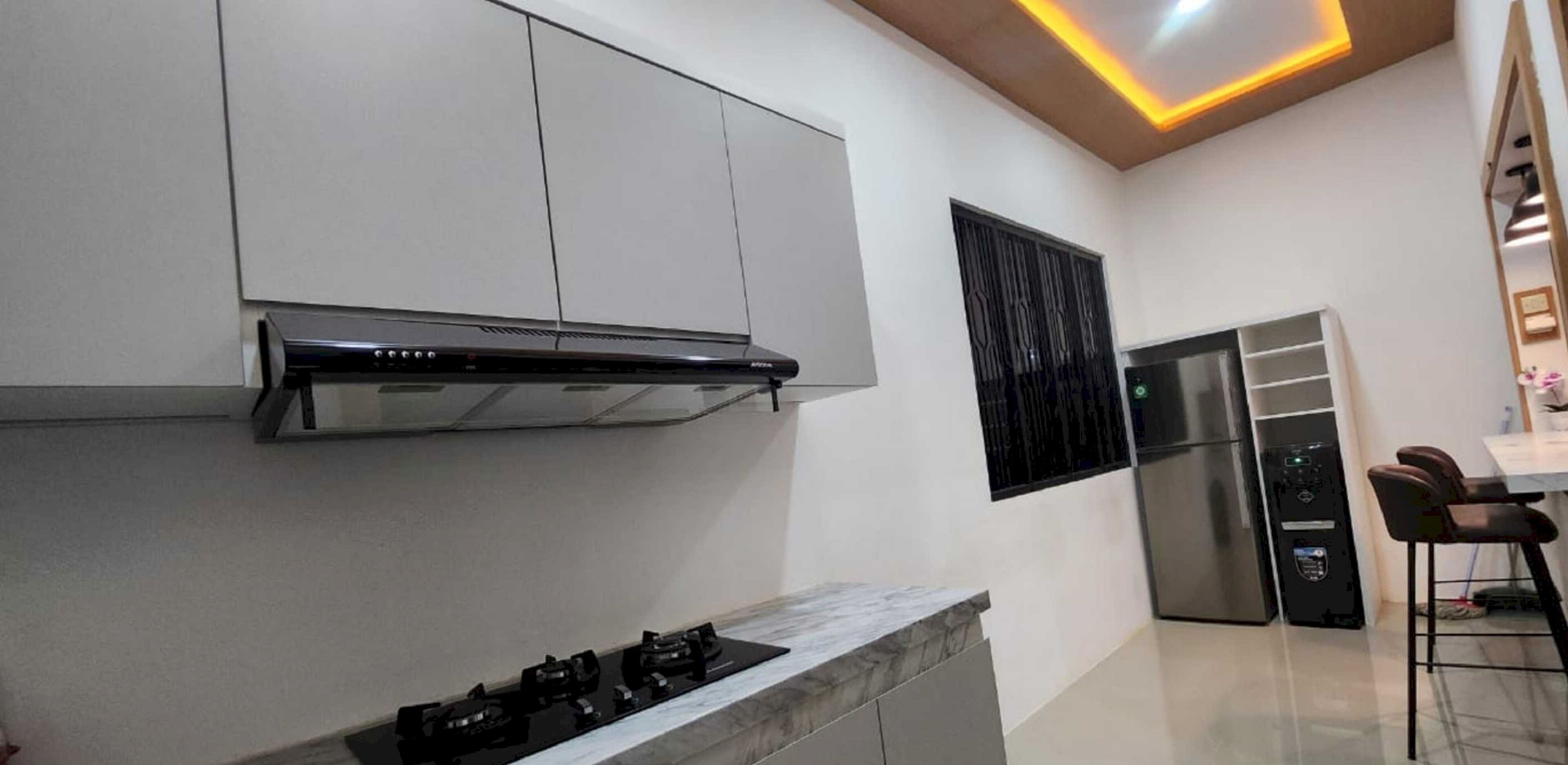 Una cocina moderna con estufa integrada, electrodomésticos de acero inoxidable y un diseño elegante.