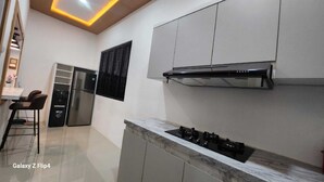 A modern kitchen with a gas stove, a built-in oven, and a stainless steel refrigerator.