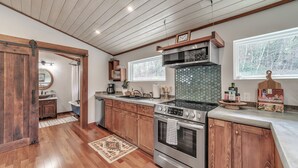 A kitchen with wooden cabinets, a stove, and a large window.