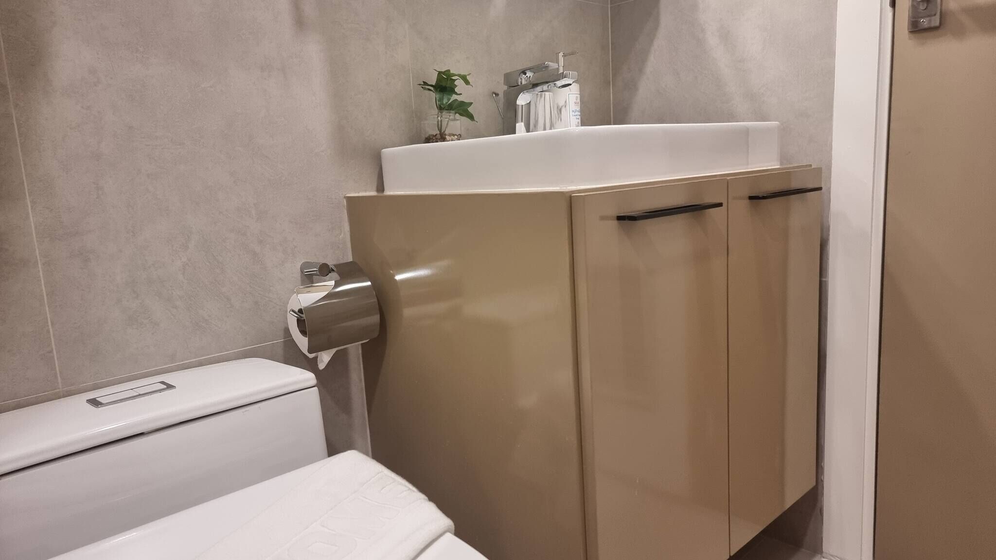 Een badkamer met een toilet, een wastafel en een kast.