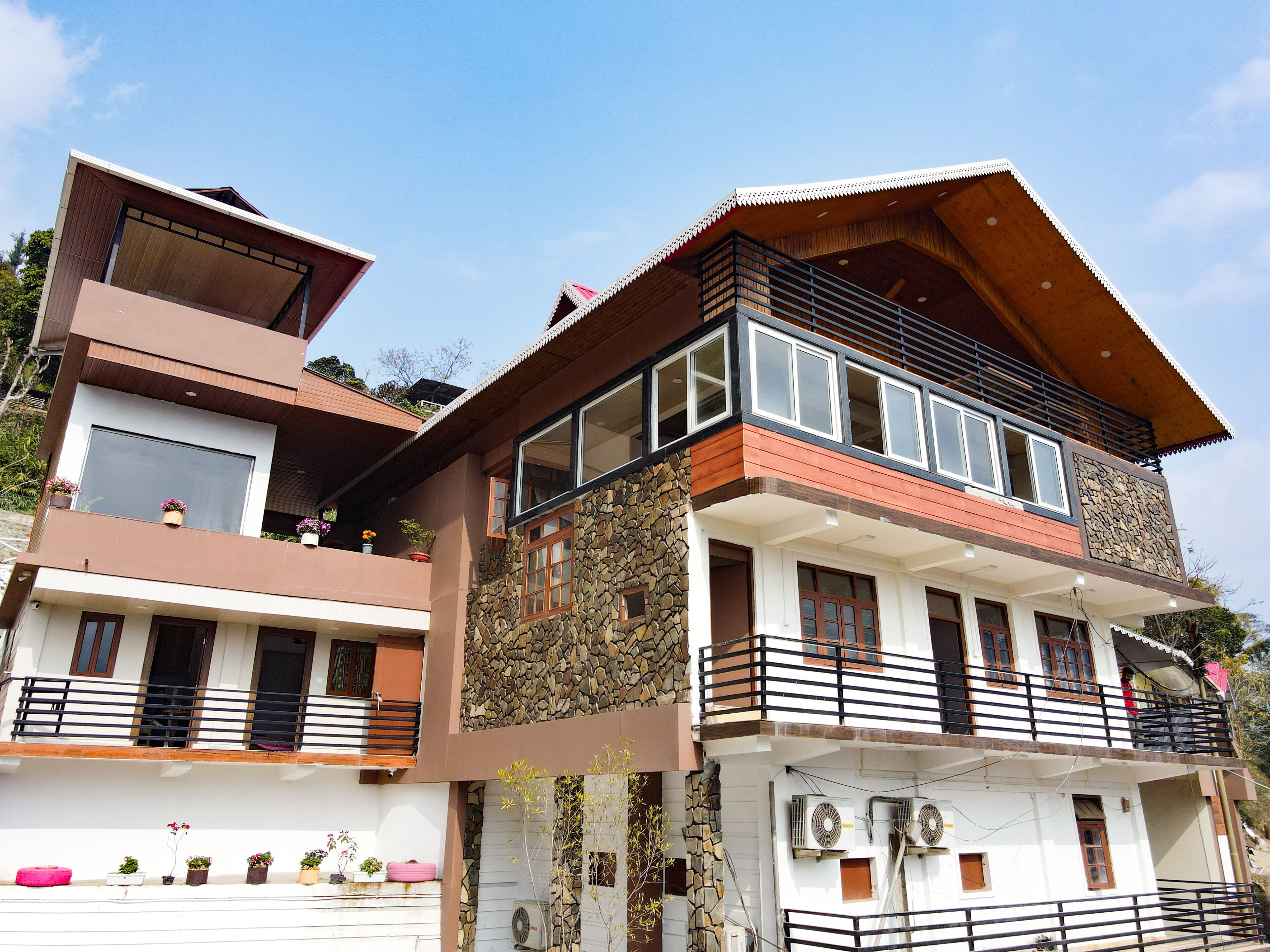 A multi-story residential building with balconies, large windows, and outdoor air conditioning units.