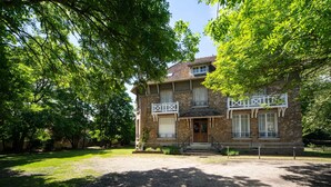 A two-story stone building with a balcony, a front porch, and a gravel driveway. - Demeure du saule Madame (Thieux)