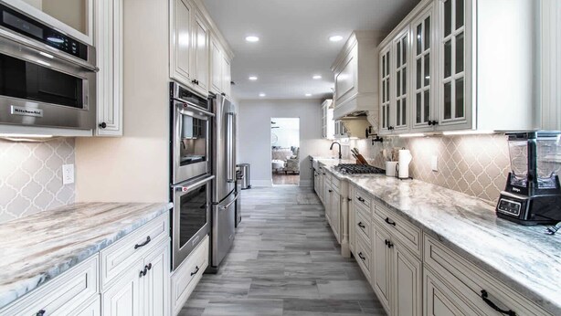 A kitchen with white cabinetry, a built-in oven, a microwave, a stove, and a blender. - Coastal Oasis - Beautiful Ocean Views Awaits (Corpus Christi)