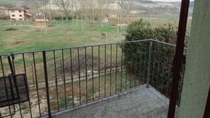 A balcony with a metal railing overlooking a grassy area with trees and buildings in the distance. - LOCANDA DEL VIANDANTE (Magliano Alfieri)