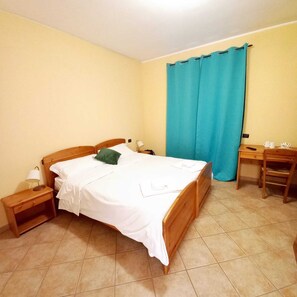 A bedroom with a bed, a nightstand, a desk, and a chair. - LOCANDA DEL VIANDANTE (Magliano Alfieri)
