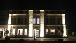 A large, well-lit building with a central entrance, multiple windows, and a symmetrical facade. - Gulmohar Royals (Cooch Behar)