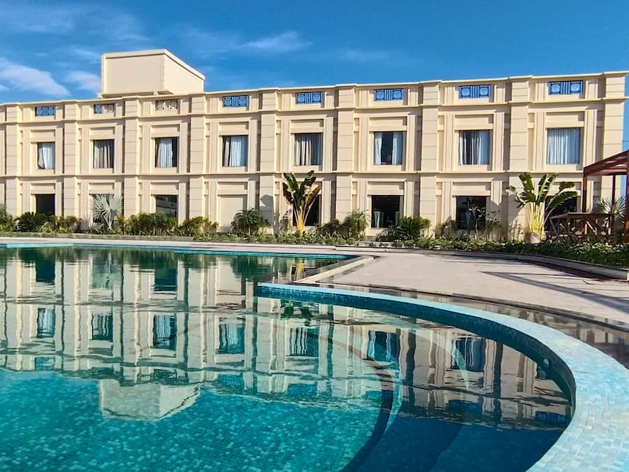Un hotel gran amb una piscina al davant.