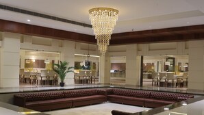 A spacious lobby with a large seating area, a grand chandelier, and a modern design. - Gulmohar Royals (Cooch Behar)