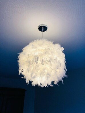 A white, fluffy chandelier with a circular design hanging from a ceiling. - Proche du Centre Ville, Appartement de 100m2, Deux Chambres, Parking Privatif (Longeville-lès-Metz)