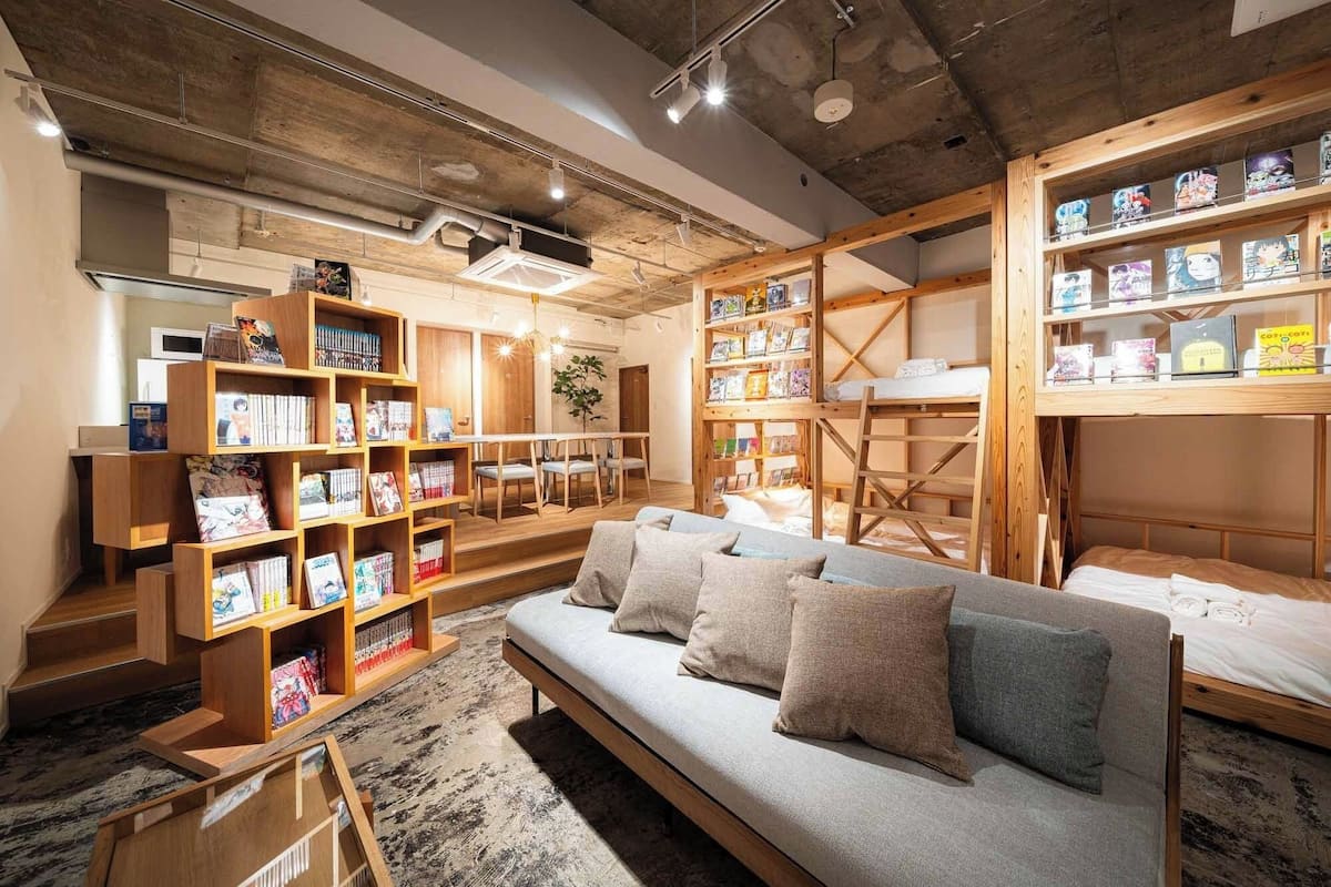 A cozy reading nook with a sofa and bookshelves filled with books and magazines.