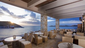 An outdoor seating area with wicker furniture and a view of the sea.