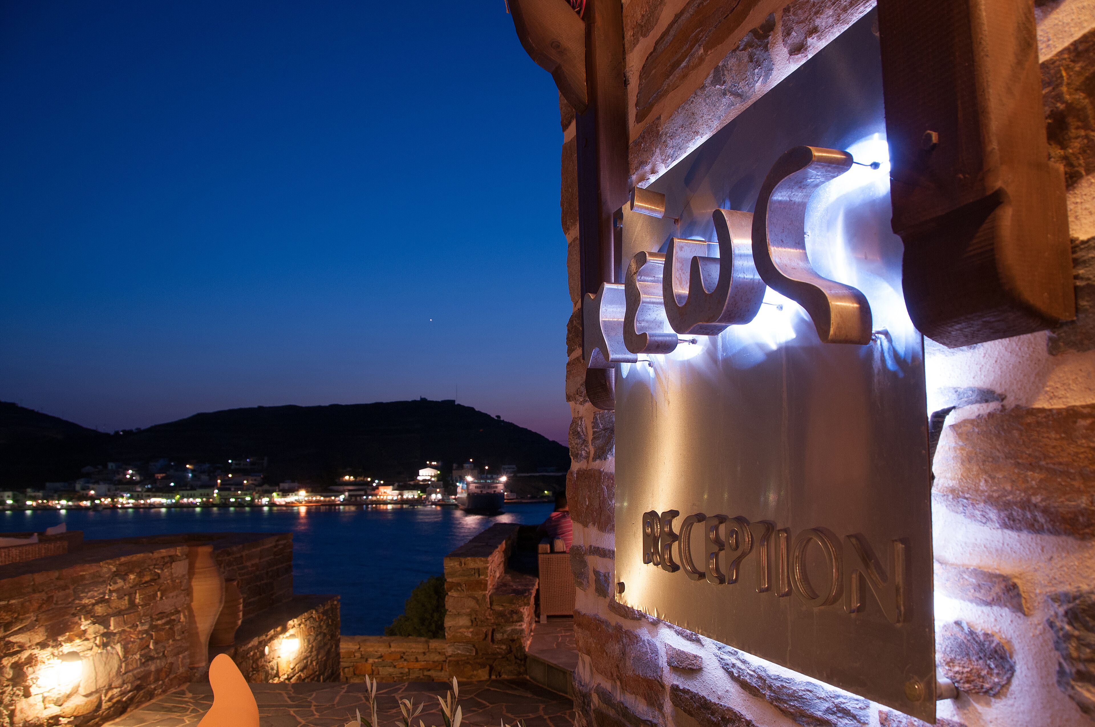 Un edificio de piedra con un cartel que dice "RECEPTION" iluminado por luces.